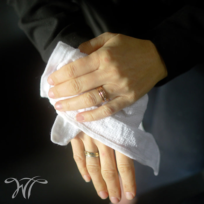 Hands being refreshed with a White Towel Services cotton refreshment towel